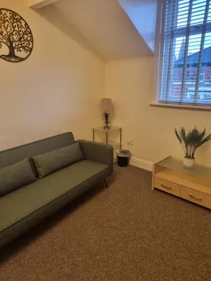 a living room with a couch and a table at Lexham Apartments in Blackpool