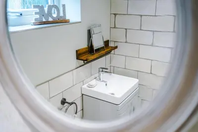 a white bathroom with a sink and a mirror at The Knoll Lodge- Beautiful Luxurious One Double Bedroom Property in Farington