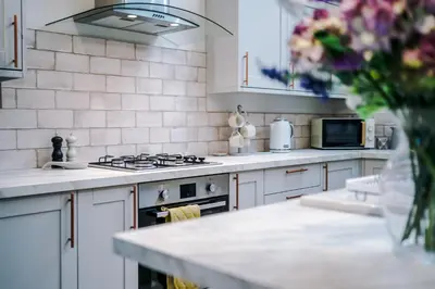 a kitchen with white appliances and a vase of flowers at The Knoll Lodge- Beautiful Luxurious One Double Bedroom Property in Farington