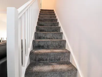 a staircase in a house with grey carpet at 3 Thrimby Court in Morecambe
