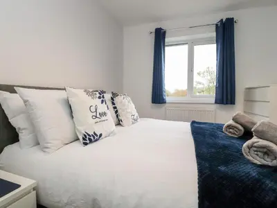 a bedroom with a white bed with pillows and a window at 3 Thrimby Court in Morecambe
