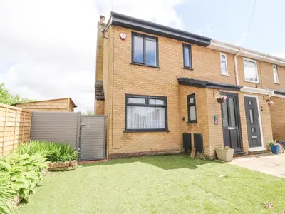 a brick house with a fence and a yard at 3 Thrimby Court in Morecambe