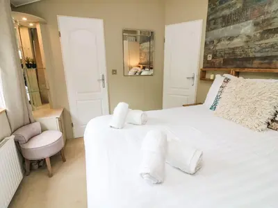 a bedroom with a large white bed with towels on it at Lakeside 12 in Carnforth