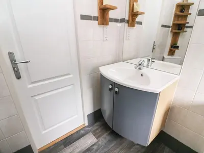 a white bathroom with a sink and a door at Lakeside 12 in Carnforth