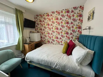 a bedroom with a bed with a blue head board at The Scala Hotel in Blackpool