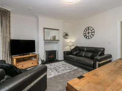 a living room with a couch and a television at Eden on the Crescent in Morecambe