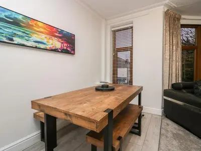 a living room with a wooden table and a couch at Eden on the Crescent in Morecambe