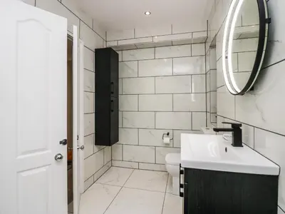 a white bathroom with a sink and a mirror at Eden on the Crescent in Morecambe