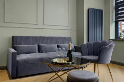 a living room with a couch and a table with a bottle of wine at Signature Apartments in Blackpool