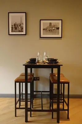 a table with chairs and wine glasses on it at Signature Apartments in Blackpool