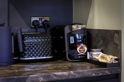 a counter with a coffee maker and a bottle of water at Signature Apartments in Blackpool