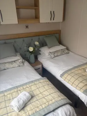 two beds in a small room with flowers on it at 8 lakeview in Clitheroe
