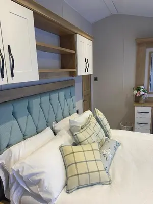 a bedroom with a bed with a blue headboard and pillows at 8 lakeview in Clitheroe