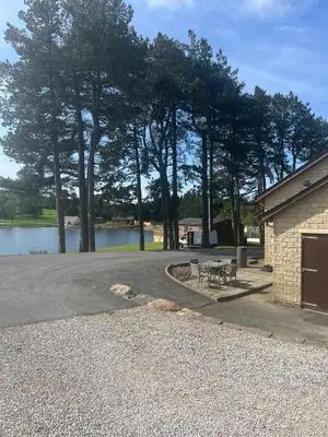 a parking lot with a picnic table and a lake at 8 lakeview in Clitheroe