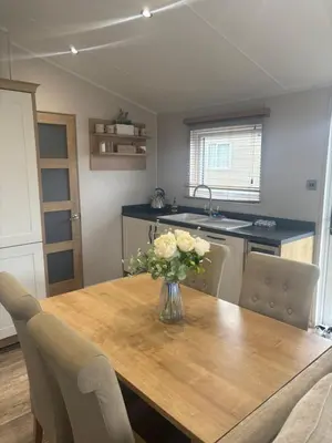a kitchen with a wooden table with a vase of flowers on it at 8 lakeview in Clitheroe
