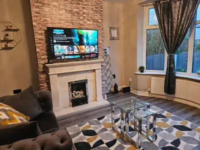 a living room with a fireplace and a flat screen tv at Number 1 Preston Stays in Preston