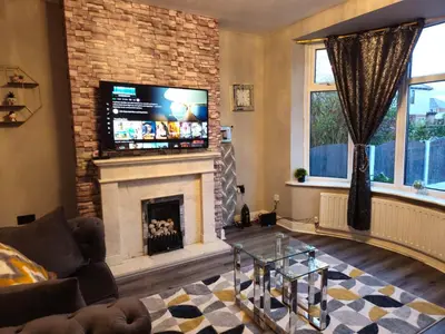 a living room with a fireplace and a flat screen tv at Number 1 Preston Stays in Preston