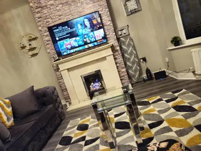 a living room with a fireplace with a flat screen tv at Number 1 Preston Stays in Preston