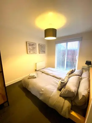 a bedroom with a bed and a large window at Lovely 2 bed apartment in Crosby in Liverpool