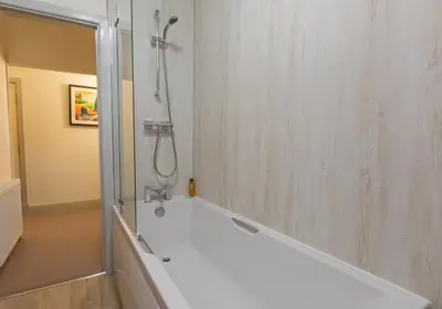 a bathroom with a shower and a bath tub at Stonyhurst Spacious apartment, great location. in Clitheroe