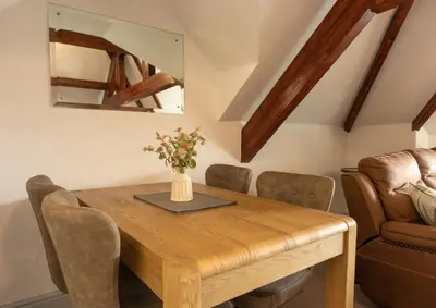 a dining room with a wooden table and a chair at Stonyhurst Spacious apartment, great location. in Clitheroe