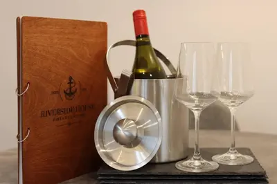 a bottle of wine and two glasses on a table at Riverside House Lancaster - 2 bedroom house in Lancaster