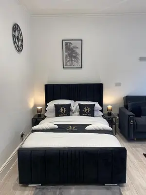 a bedroom with a large bed with a black headboard at Holiday Plus - Palatine Road in Blackpool