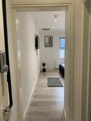 a hallway leading to a living room with white walls at Holiday Plus - Palatine Road in Blackpool