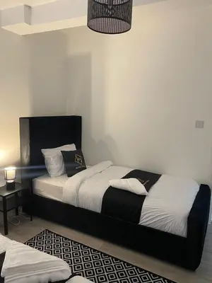 a bedroom with two beds with white and black sheets at Holiday Plus - Palatine Road in Blackpool
