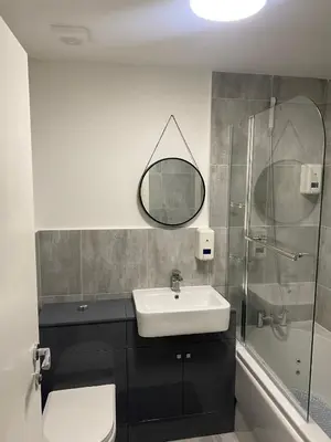 a bathroom with a sink and a glass shower at Holiday Plus - Palatine Road in Blackpool
