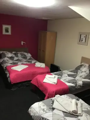 a hotel room with two beds with red sheets at Mr smiths/ The old Stanley arms in Liverpool
