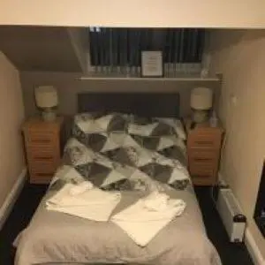 a bed in a room with two dressers and two lamps at Mr smiths/ The old Stanley arms in Liverpool