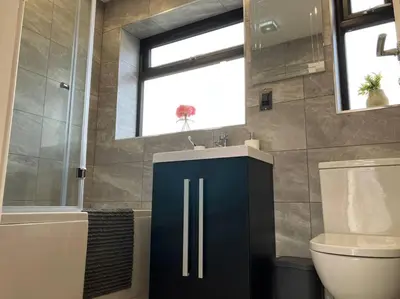 a bathroom with a sink and a toilet and a window at Newly renovated, modern bungalow - quiet location in Lytham St Annes