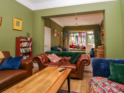 a living room with leather couches and a wooden table at Sunnycote in Carnforth