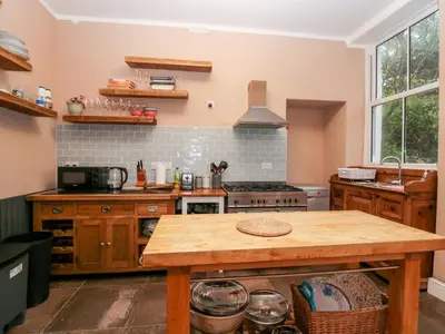 a kitchen with a wooden table and a stove at Sunnycote in Carnforth