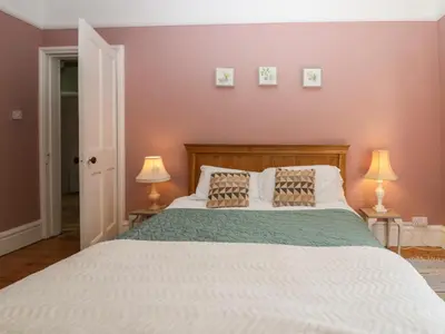 a bedroom with a large white bed with two lamps at Sunnycote in Carnforth