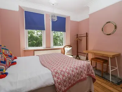 a bedroom with a bed and a desk and two windows at Sunnycote in Carnforth