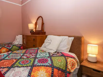 a bedroom with two beds and a table with lamps at Sunnycote in Carnforth
