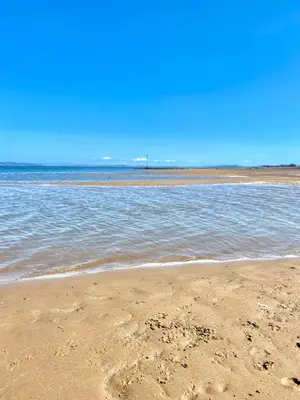 a sandy beach with the ocean in the background at Eden Stay in Morecambe