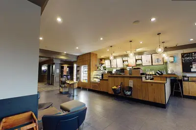 a restaurant with a counter and chairs in a room at Village Hotel Blackpool in Blackpool