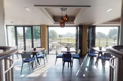 a restaurant with tables and chairs and windows at Village Hotel Blackpool in Blackpool