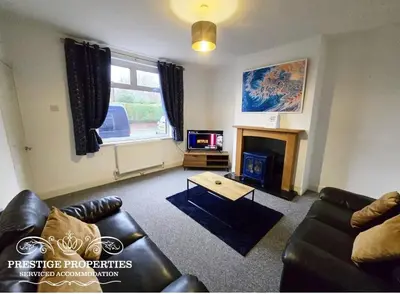 a living room with a couch and a fireplace at 8 Suffolk street by Prestige Properties SA in Barrow in Furness
