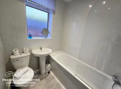 a bathroom with a sink and a toilet and a tub at 8 Suffolk street by Prestige Properties SA in Barrow in Furness