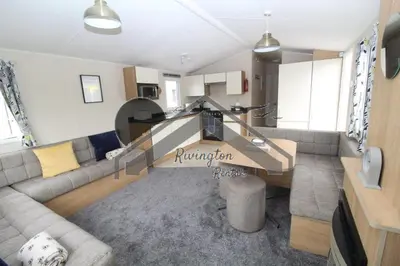 a living room with a couch and a table at Serenity - 8 Berth 3 Bedroom Static Caravan in Heysham