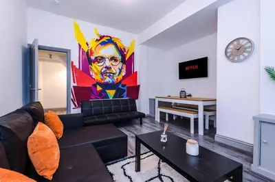 a living room with a couch and a painting on the wall at LFC Football Apartment Anfield in Liverpool