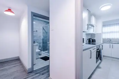 a white kitchen with a sink and a shower at LFC Football Apartment Anfield in Liverpool
