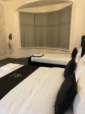 a hotel room with two beds and a window at Holiday Plus - Holmfield Road in Blackpool