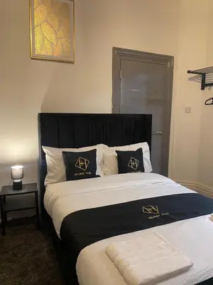 a bed with black and white pillows in a bedroom at Holiday Plus - Holmfield Road in Blackpool