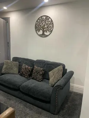 a couch in a living room with a plate on the wall at Holiday Plus - Holmfield Road in Blackpool