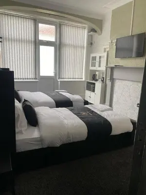 a group of four beds in a room at Holiday Plus - Holmfield Road in Blackpool